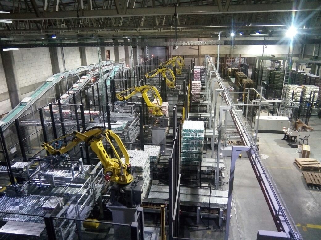 Almacén interior en nave con racks y robots paletizadores integrados, montaje intralogístico de Aiyra Electromecánica